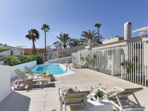 eine Terrasse mit Stühlen und einem Swimmingpool in der Unterkunft VelSuites Playa del Ingles by VillaGranCanaria in Playa del Ingles