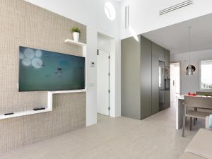 ein Wohnzimmer mit einem Flachbildfernseher an der Wand in der Unterkunft VelSuites Playa del Ingles by VillaGranCanaria in Playa del Ingles