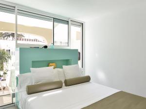 ein Schlafzimmer mit einem weißen Bett und einem großen Fenster in der Unterkunft VelSuites Playa del Ingles by VillaGranCanaria in Playa del Ingles