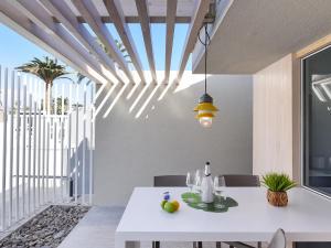 ein Esszimmer mit einem weißen Tisch und einem Fenster in der Unterkunft VelSuites Playa del Ingles by VillaGranCanaria in Playa del Ingles