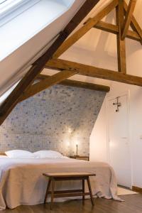 a bedroom with a bed and a brick wall at Apartments Ridderspoor in Bruges