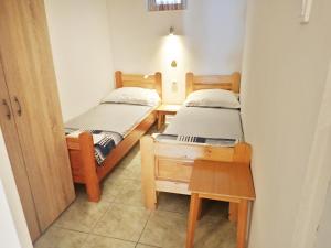 two twin beds in a room with a table at Apartments Nada in Starigrad-Paklenica