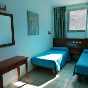 a room with two beds and a table and a window at Marianela Apartment in Puerto Rico de Gran Canaria +77 photos