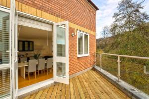 a balcony with a door and a table and chairs at School Path Ironbridge Townhouse with Roof Terrace in Ironbridge