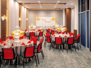 新加坡Ibis Singapore on Bencoolen - Newly Renovated的一间会议室,配有桌子和红色椅子