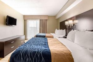 a hotel room with two beds and a flat screen tv at Comfort Inn Airport West in Mississauga