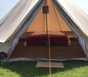a white tent with a bed in the grass at 4Ever TT Glamping in Colby
