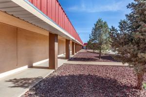 a building with a red roof and a sidewalk at Econo Lodge Clovis in Clovis