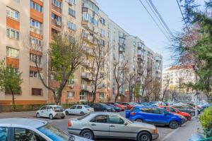 Un mucchio di auto parcheggiate di fronte a edifici alti di Studio T by MRG Apartments a Bucarest