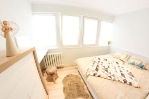 biała sypialnia z łóżkiem i oknami w obiekcie Apartamenty u Piątków w mieście Karpacz