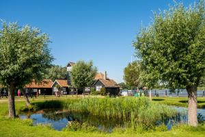un estanque en un parque con árboles y casas en Sanctuary House, en Thorpeness