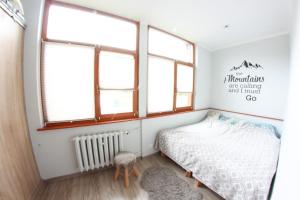 małą sypialnię z łóżkiem i oknami w obiekcie Apartamenty u Piątków w mieście Karpacz