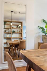 a dining room with a table and chairs and a mirror at Apartments Ridderspoor in Bruges