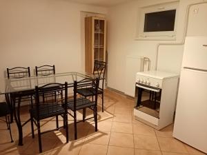 cocina con mesa, sillas y nevera blanca en Eötvös nyaraló, en Siófok 9 fotos más