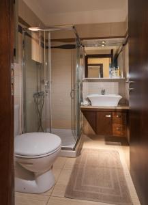a bathroom with a toilet and a shower and a sink at Aroma Villas in Hersonissos