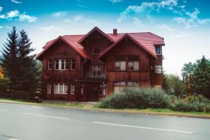 カルパチにあるApartamenty u Piątkówの道路脇の赤い屋根の木造家屋