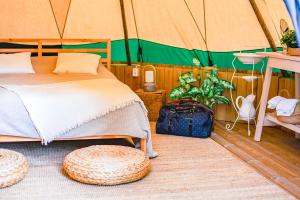 a bedroom with a bed in a tent at Årjäng Camping & Stugor Sommarvik in Årjäng
