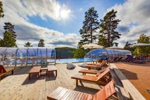 una piscina con bancos y sombrillas en una terraza en Årjäng Camping & Stugor Sommarvik en Årjäng