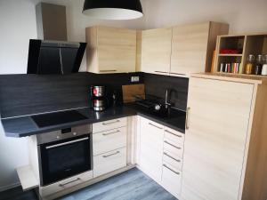 uma cozinha com armários brancos e um balcão preto em Daheym FEWO 1 em Erfurt