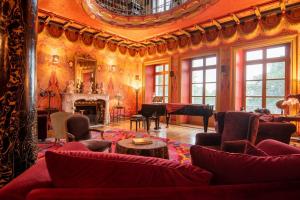 een woonkamer met rode meubels en een open haard bij Chateau de Bézyl in Sixt-sur-Aff