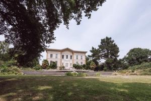 a large white house with a lawn in front of it at Chateau de Bézyl in Sixt-sur-Aff