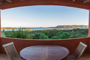 a table and chairs on a porch with a large window at Royal Palm in Porto-Vecchio