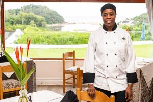 un chef parado frente a una mesa en The Estuary Hotel & Spa en Port Edward