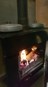 a oven with a fire inside of it at Chalet du Spièmont in Champdray
