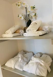 two shelves with towels and a vase of flowers at Private Spa LUX with Whirlpool and Sauna in Zurich in Zurich