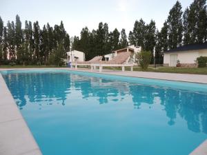a large swimming pool with blue water at Cabañas Terruños de Pilar in Malargüe