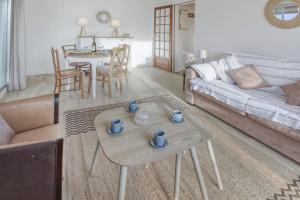 a living room with a couch and a table at Le Sterne in Pléneuf-Val-André