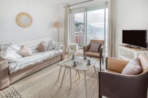a living room with a couch and a table and chairs at Le Sterne in Pléneuf-Val-André