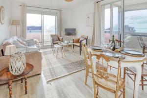 a living room with a table and chairs and a couch at Le Sterne in Pléneuf-Val-André