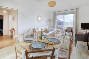 a dining room and living room with a table and chairs at Le Sterne in Pléneuf-Val-André +10 photos