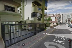 a building with a gate on the side of a street at Apto Meia Praia in Itapema