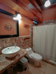 a bathroom with a white sink and a toilet at Hotel Utz Jay in Panajachel