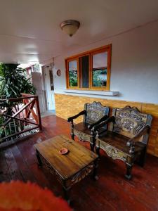 a living room with two chairs and a wooden table at Hotel Utz Jay in Panajachel