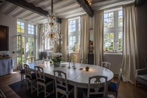 uma sala de jantar com uma mesa e cadeiras e um lustre em Faubourg Saint Martin em Liège