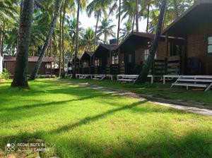 a building with palm trees in front of it at Agonda Paradise in Agonda