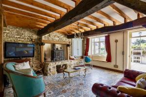 un soggiorno con divano e TV di Glatigny Farmhouse - close to beach - proche de la plage a Glatigny