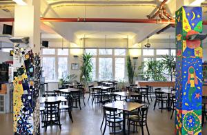 una sala da pranzo con tavoli, sedie e finestre di Hotel Transit Loft a Berlino
