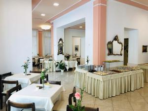 un ristorante con tavoli, sedie e uno specchio di Hotel Eletto a Sanremo