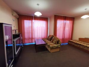 a living room with a couch and a flat screen tv at Villa Iztok in Sozopol