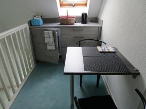 een tafel en stoelen in een kleine keuken met een koelkast bij Bed & Breakfast Wunstorf in Wunstorf