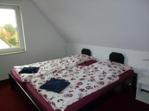 een slaapkamer met een bed met een wit en rood dekbed bij Bed & Breakfast Wunstorf in Wunstorf