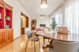 a dining room with a table with a laptop on it at Frank's and Art Love Apartments in Livorno