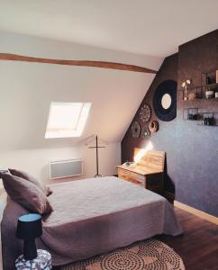 a bedroom with a bed and a desk and a window at L'Aubinoise in Saint-Aubin-de-Luigné