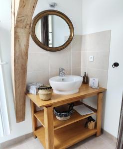 La salle de bains est pourvue d'un lavabo et d'un miroir. dans l'établissement L'Aubinoise, à Saint-Aubin-de-Luigné