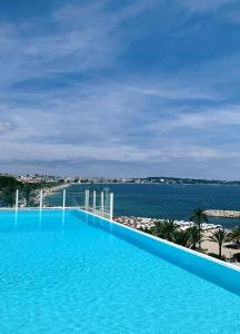 a large swimming pool with a view of the ocean at Palais Napoléon, Golfe Juan in Vallauris
