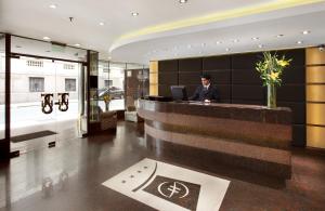 un homme assis à un bureau dans le hall de l'hôtel dans l'établissement Hotel Sheltown, à Buenos Aires